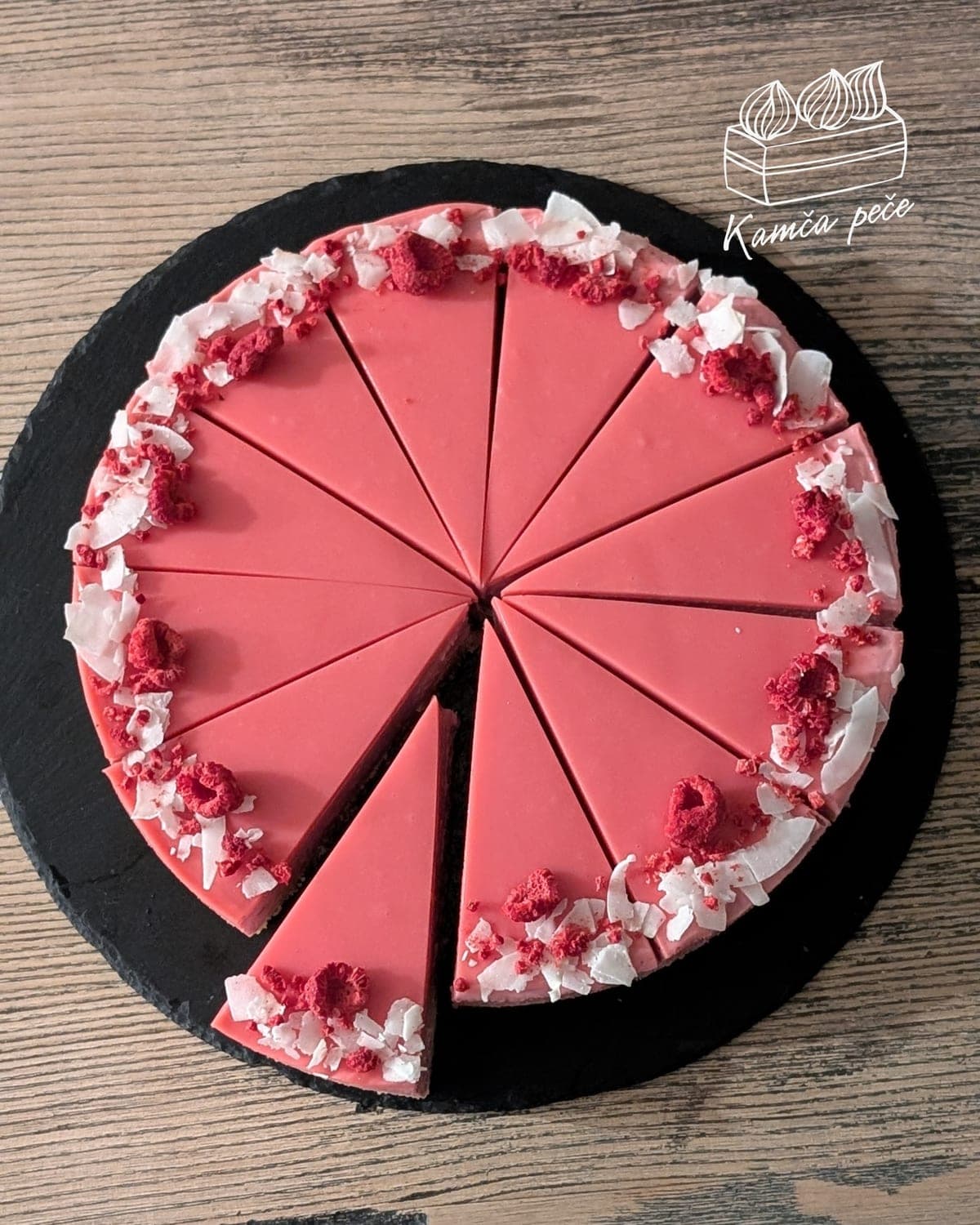 Nakrájený malinový cheesecake s růžovou polevou, sušenými malinami a kokosovými lupínky